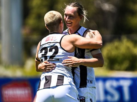 Two Collingwood AFLW players celebrate a goal against West Coast.
