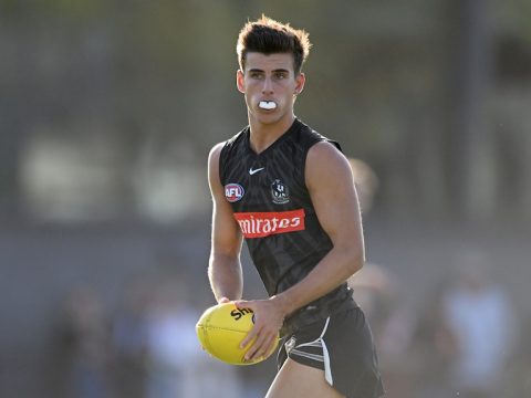 Nick Daicos looks up while running with the ball