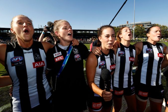 Several Collingwood AFLW players sing the club song after beating Richmond.