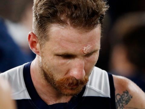 Zach Tuohy looks down. He has a visible cut above his left eyebrow