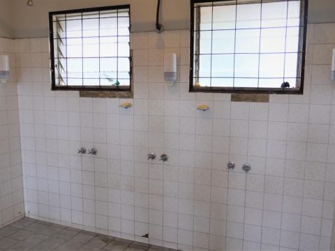 Old communal shower with no doors.