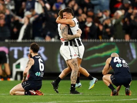 Two Collingwood AFL players embrace as they celebrate beating Carlton.