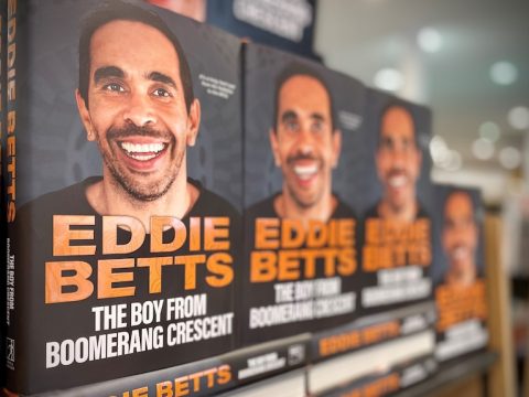 books of eddie betts on bookshelf, with his face on the front cover.