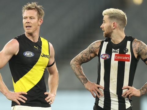 Two AFL players from Richmond and Collingwood stand side by side with hands on hips after a drawn game.