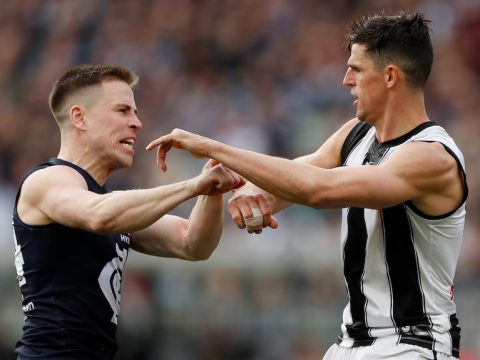 A Carlton AFL player scuffles with a Collingwood opponent.