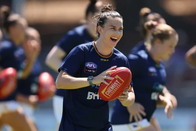 Eloise Jones holds a football and laughs.