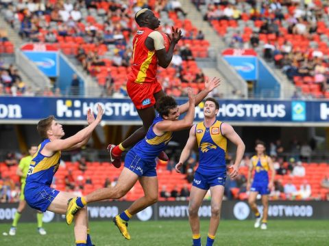 A Gold Coast AFL player takes an aerial mark over a West Coast opponent.
