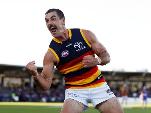 Adelaide AFL star Taylor Walker roars and punches the air in celebration after kicking a last-minute goal.