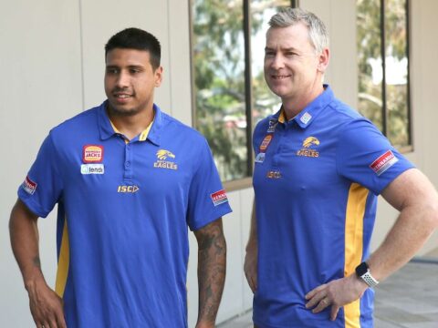 Tim Kelly stands next to Adam Simpson with both men smiling and wearing blue West Coast Eagles shirts.