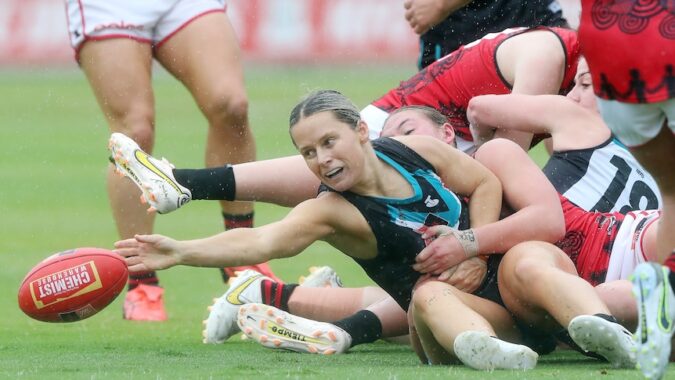 Kate Surman reaches for the football amongst a pack of Port Adelaide and Essendon players