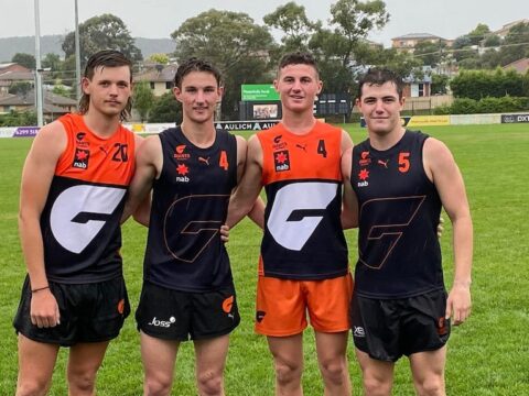 A line of young men wearing AFL attire on an AFL oval